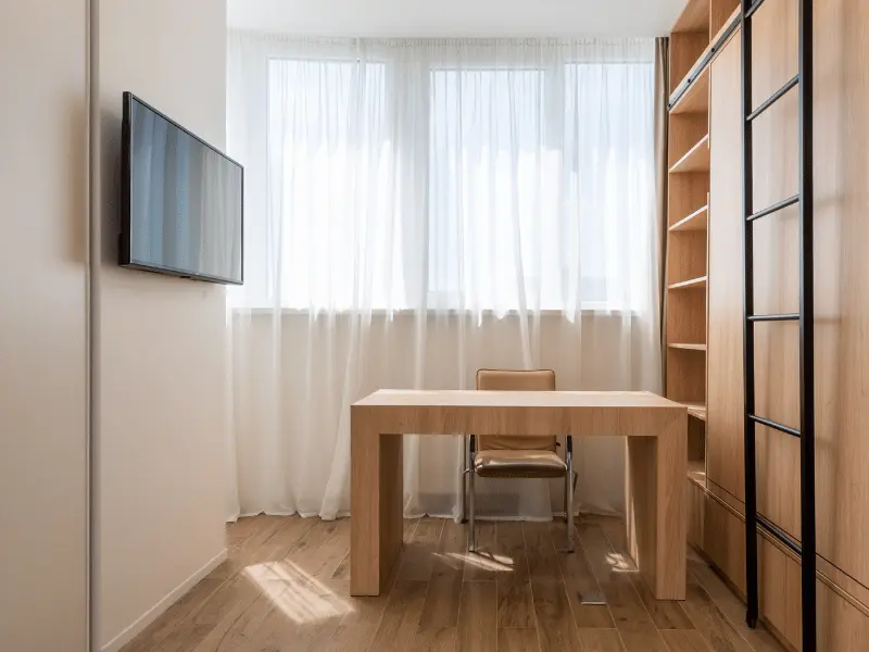 Bright room with table and tv with office setup